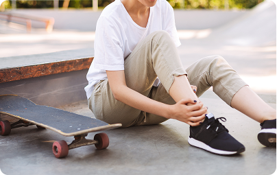 Skateboarder holding an injured ankle